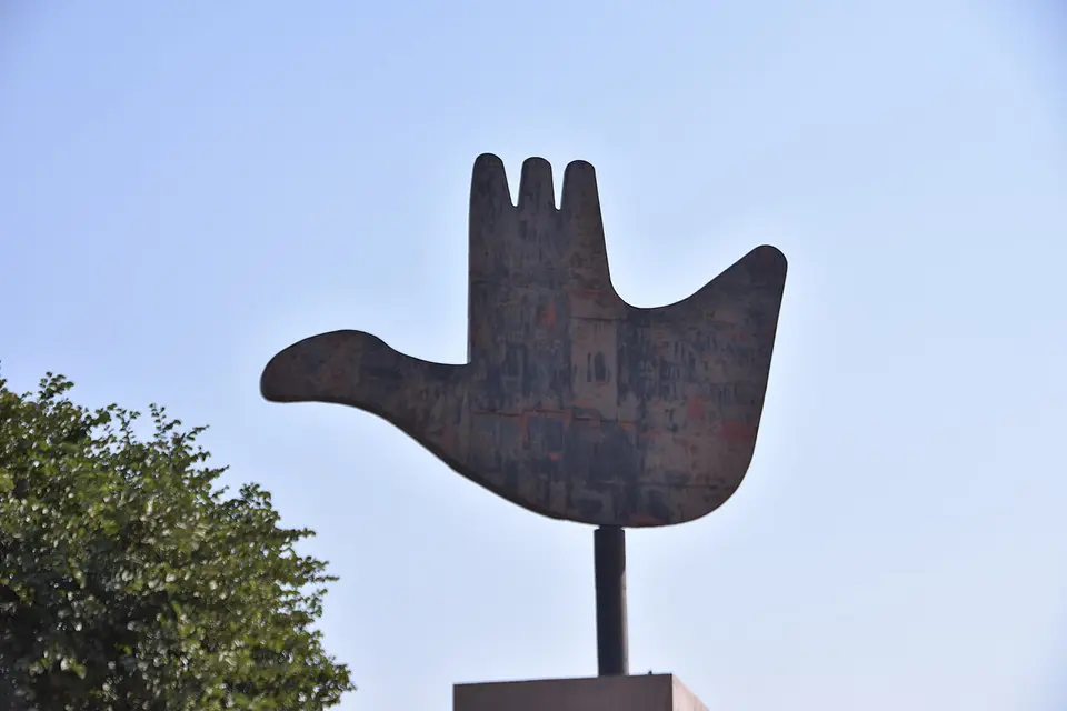 The Open Hand Monument in Chandigarh against a pale sky